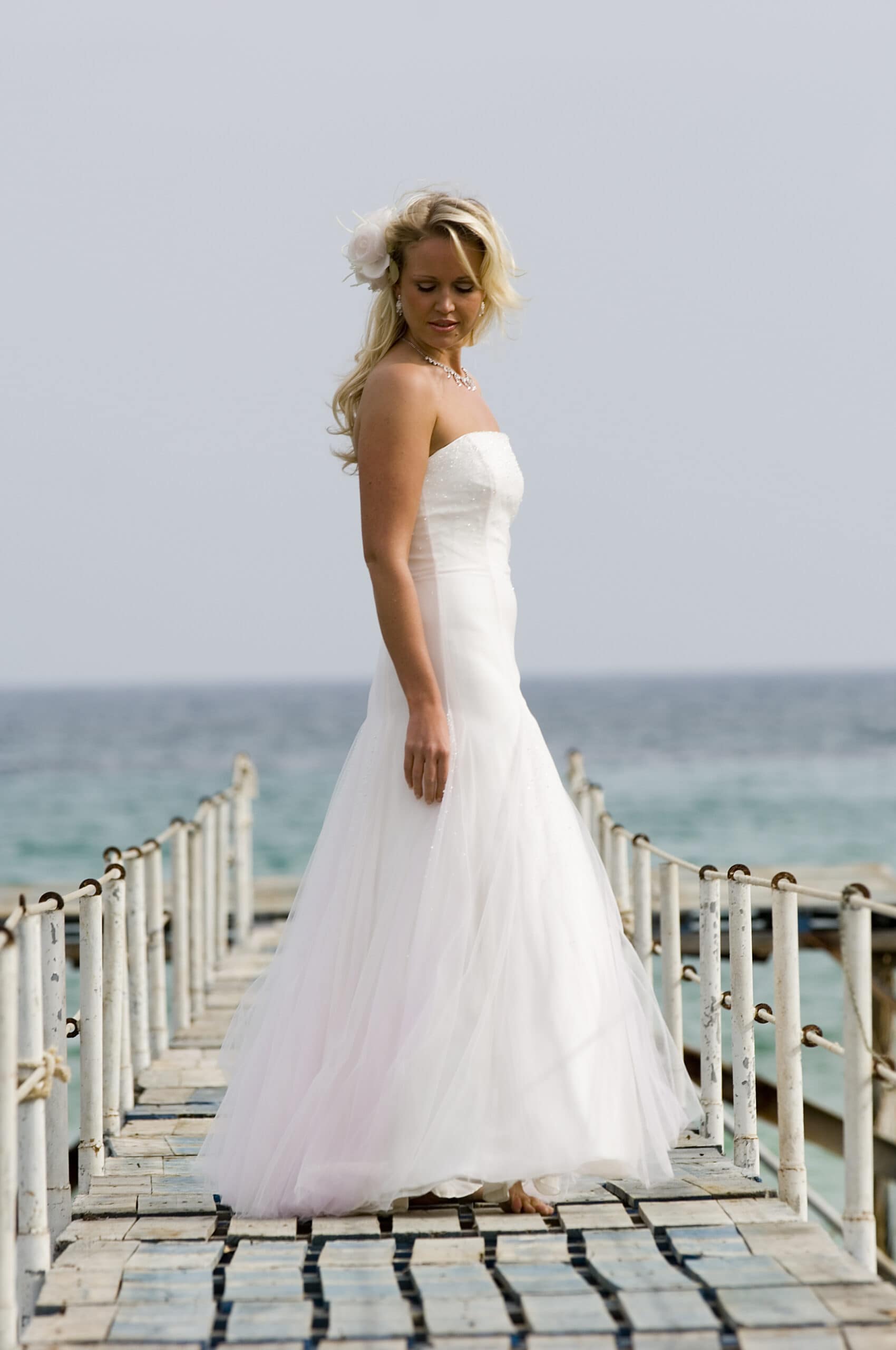 model on jetty in Cyprus wearing ivory and pink tulle wedding dress