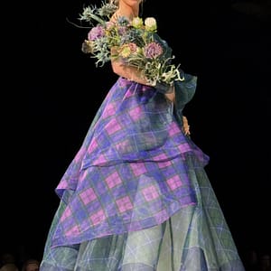 model posing on catwalk in tartan organza balgown