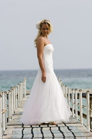 model on jetty in Cyprus wearing ivory and pink tulle wedding dress